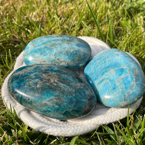 Trois galets d'apatite posés dans l'herbe
