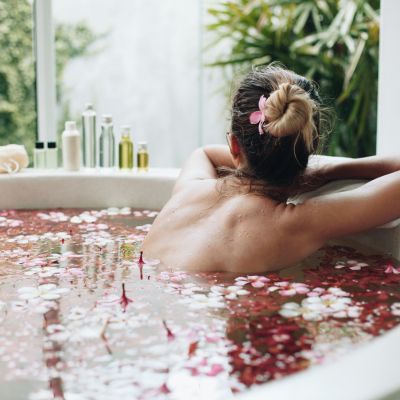 Femme se prélassant dans son bain rempli de fleurs fraîchement coupées