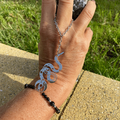 Bracelet (bijoux de main composé d'un bracelet qui s'accroche également sur le majeur) sur le thème Halloween avec une breloque argent représentant une serpent mystique, composé d'agate noire - vue de face