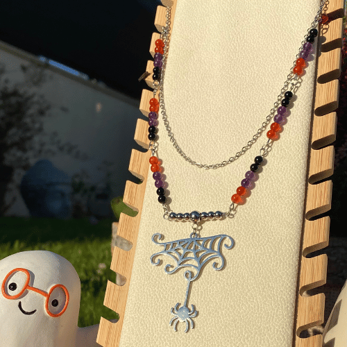 Collier sur le thème Halloween avec une breloque représentant une araignée qui sort de sa toile , composé d'améthyste, cornaline et d'onyx noir - vue de face