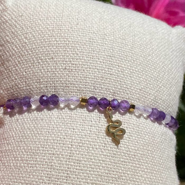 Bracelet bohème fait main en améthyste et cristal de roche, monté sur fil violet avec apprêts dorés et breloque serpent, signé Les Merveilles by Pauline.