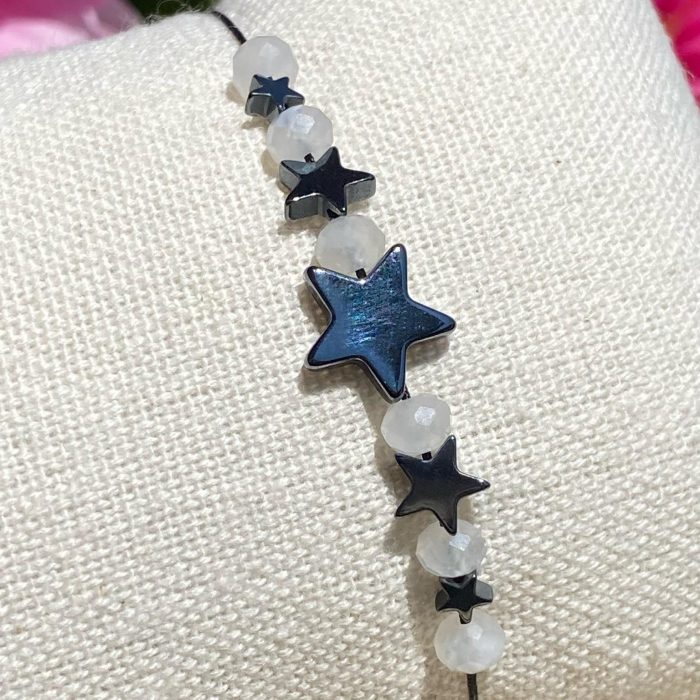 Bracelet bohème fait main en pierre de lune bleutée et hématite représentant des étoiles, monté sur fil noir, signé Les Merveilles by Pauline.