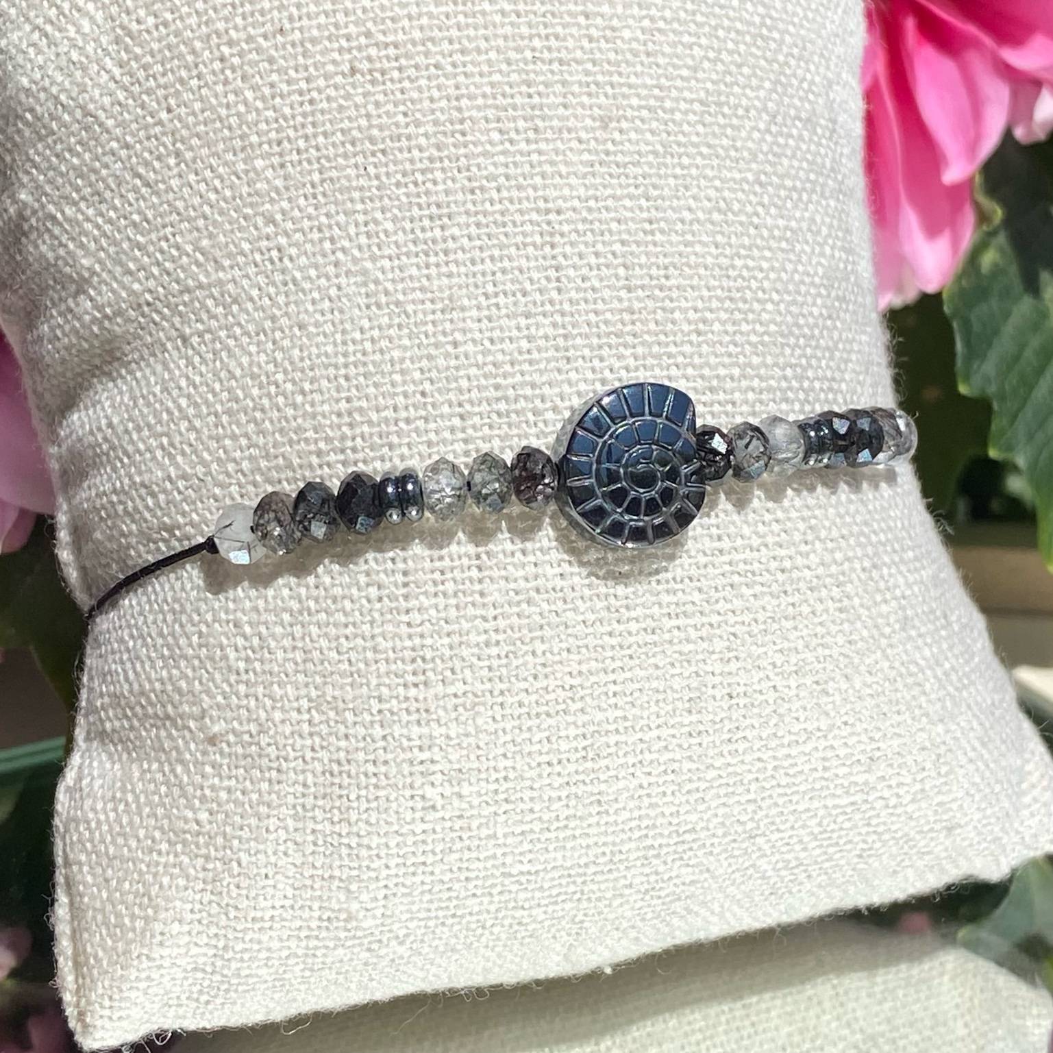 Bracelet bohème fait main en quartz tourmaline, perle centrale en hématite représentant un coquillage amonite, monté sur fil noir, signé Les Merveilles by Pauline.