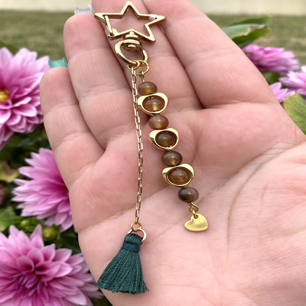 Porte-clé en agate avec des perles en forme de cœur qui entoure quelques perles, avec pompon vert foncé suspendu par une chaîne et une breloque cœur doré, fait main