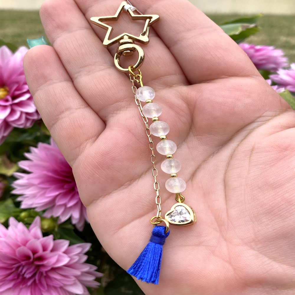 Porte-clé en sélénite avec pompon bleu roi suspendu à une chaîne et une breloque cœur doré contenant un strass, fait main