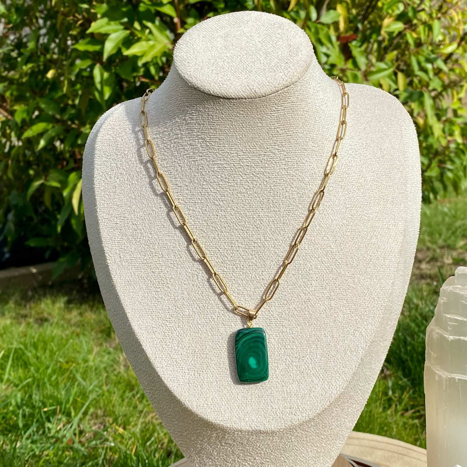 Pendentif en malachite naturelle sur chaîne à mailles rectangulaires en acier inoxydable doré. Pierre reliée au chakra du coeur : guérison émotionnelle et transformation, aux motifs verts uniques. Bijou élégant et énergétique Les Merveilles by Pauline.