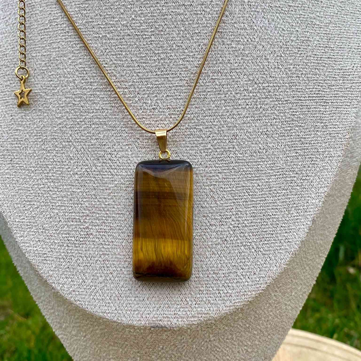 Collier pendentif œil de tigre naturel sur chaîne fine dorée ou argentée. Pierre de protection et de confiance en soi, taillée en rectangle aux coins arrondis. Création vendue par Les Merveilles by Pauline.