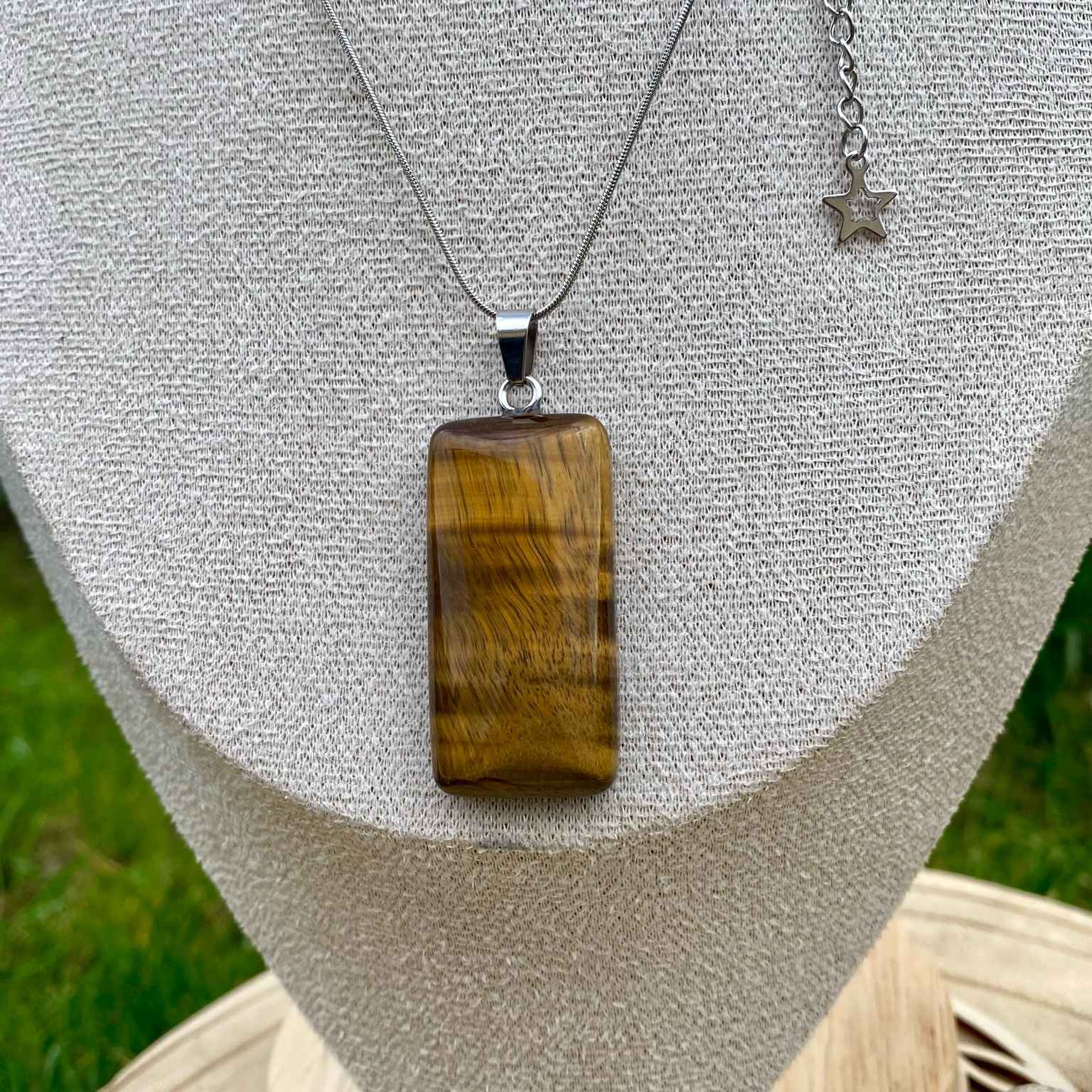 Collier pendentif œil de tigre naturel sur chaîne fine dorée ou argentée. Pierre de protection et de confiance en soi, taillée en rectangle aux coins arrondis. Création vendue par Les Merveilles by Pauline.