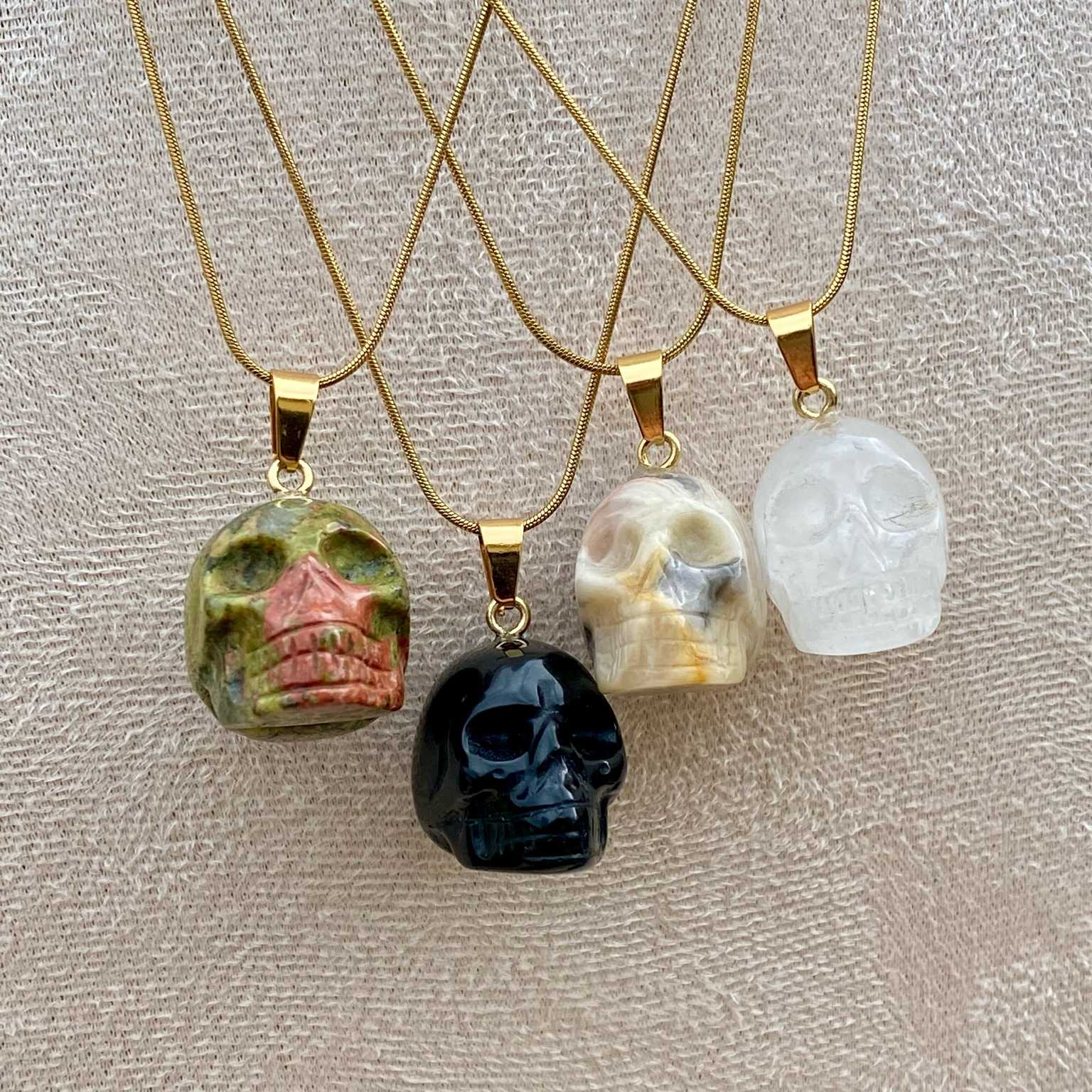 Pendentifs en unakite, onyx noir, jaspe bumble bee et cristal de roche taillé en forme de crâne. Par Les Merveilles by Pauline, bijoux énergétiques et good vibes.