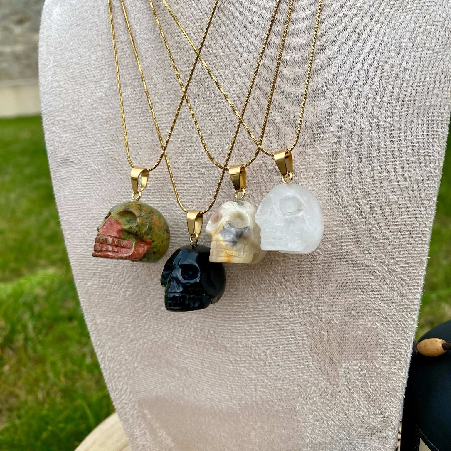 Pendentifs en unakite, onyx noir, jaspe bumble bee et cristal de roche taillé en forme de crâne. Par Les Merveilles by Pauline, bijoux énergétiques et good vibes.