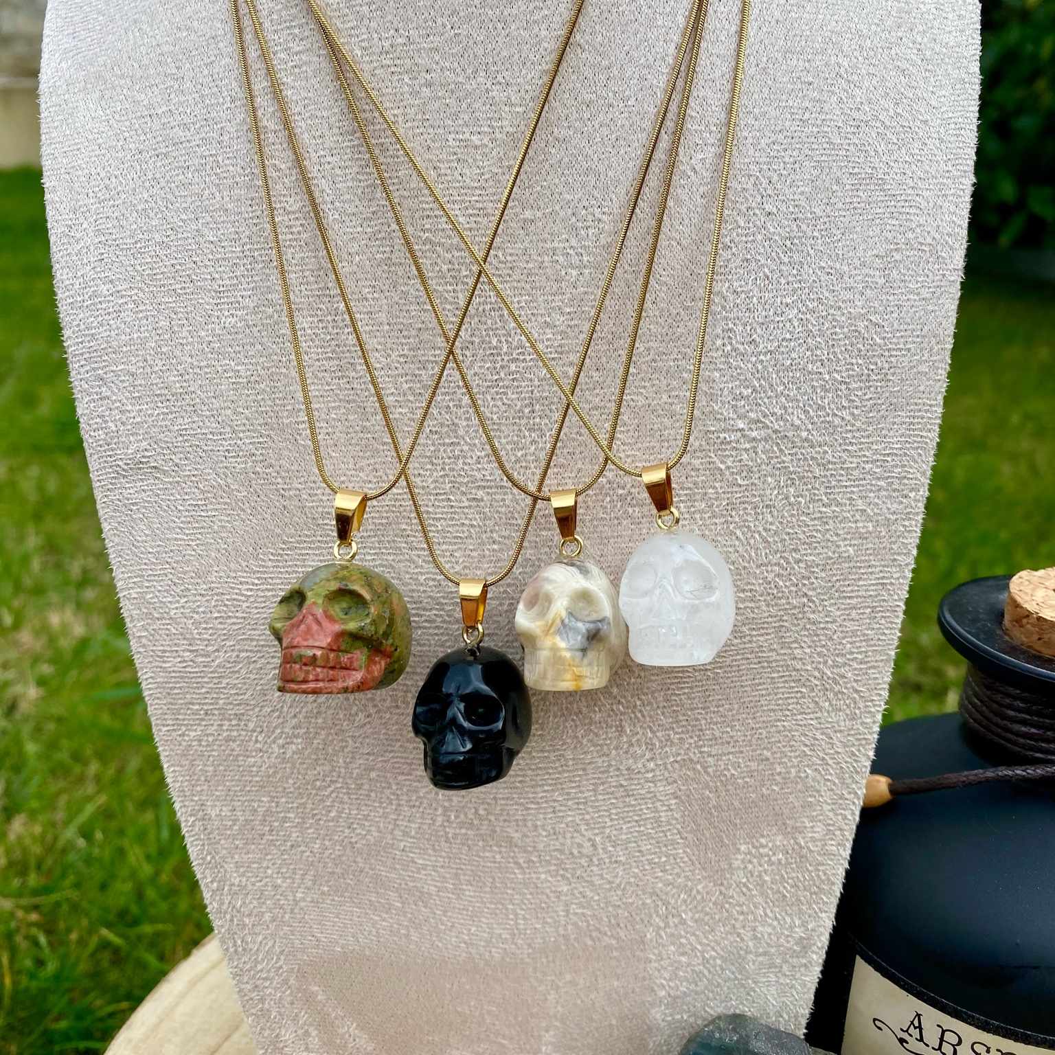 Pendentifs en unakite, onyx noir, jaspe bumble bee et cristal de roche taillé en forme de crâne. Par Les Merveilles by Pauline, bijoux énergétiques et good vibes.
