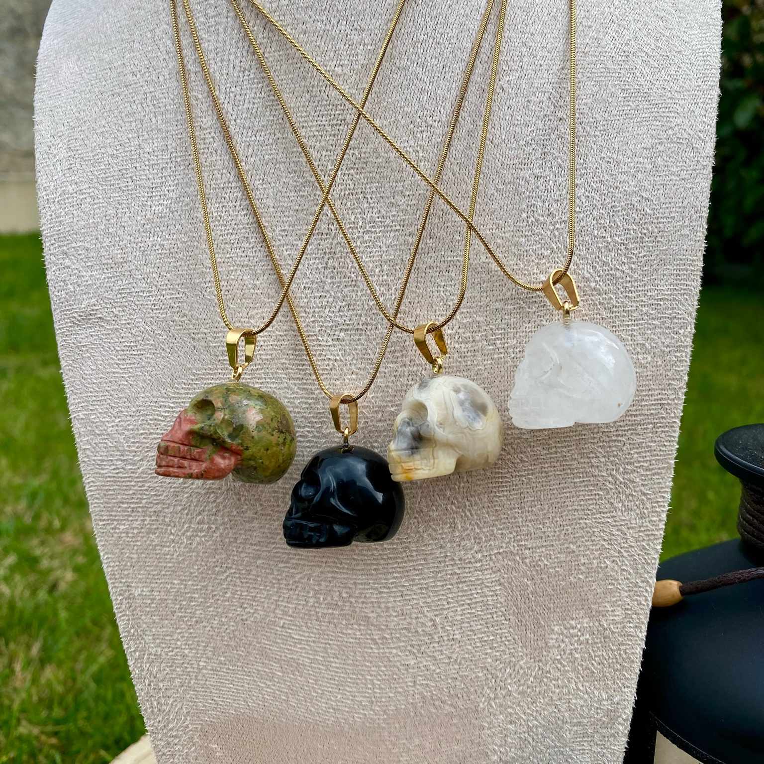 Pendentifs en unakite, onyx noir, jaspe bumble bee et cristal de roche taillé en forme de crâne. Par Les Merveilles by Pauline, bijoux énergétiques et good vibes.