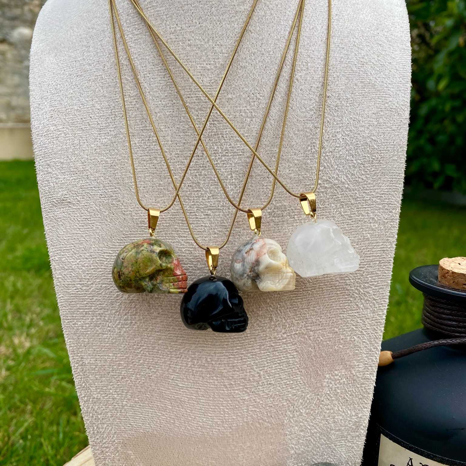 Pendentifs en unakite, onyx noir, jaspe bumble bee et cristal de roche taillé en forme de crâne. Par Les Merveilles by Pauline, bijoux énergétiques et good vibes.