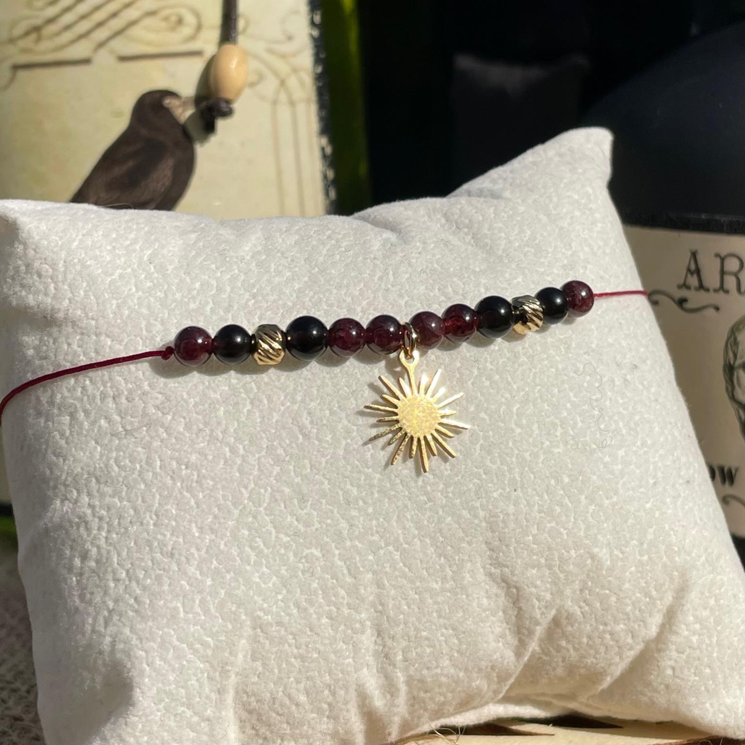 Bracelet Mère Gothel en grenat et obsidienne avec breloque soleil argentée, bijou sombre et symbolique en pierres naturelles fait main Les Merveilles by Pauline. Collection inspiré par les Méchants Disney.