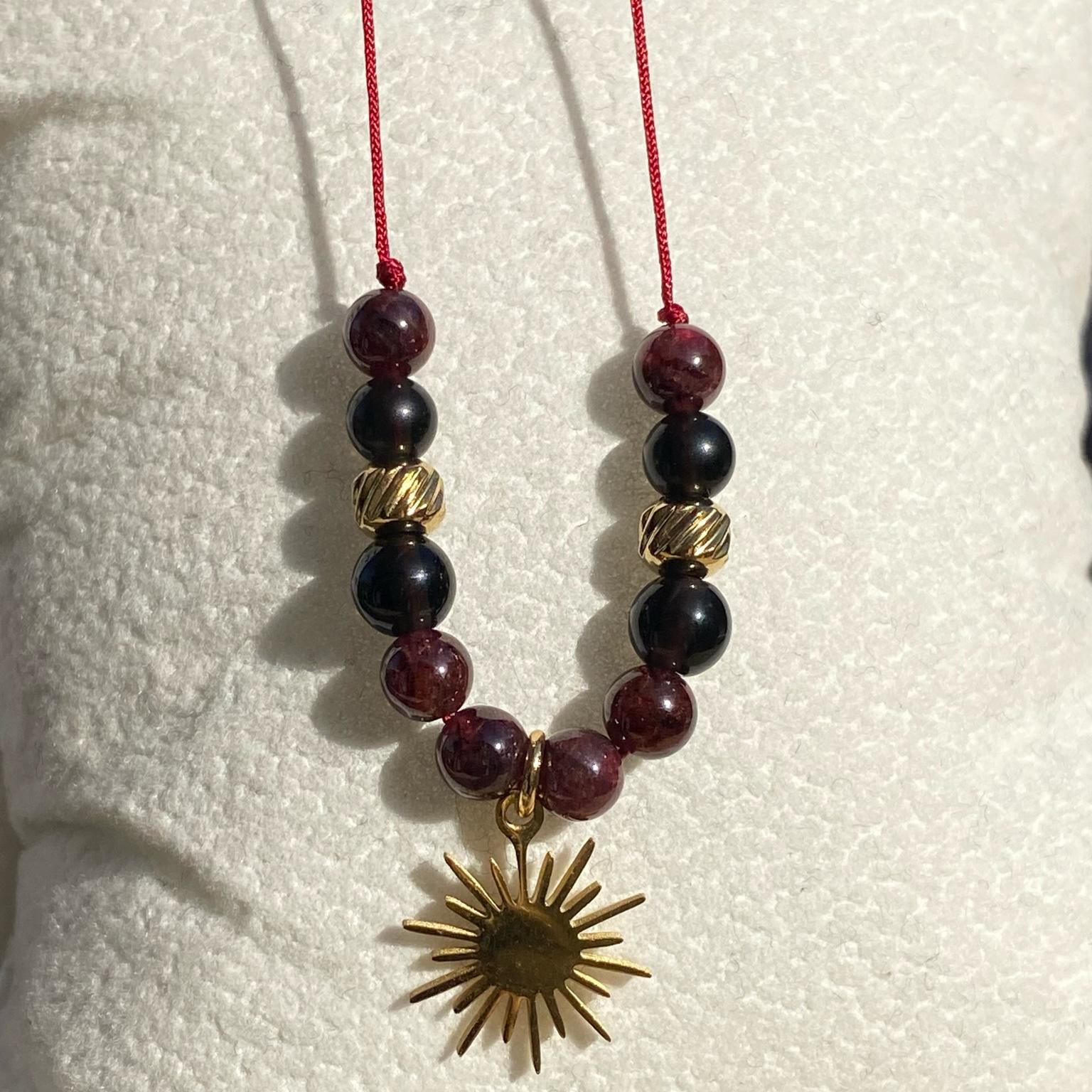 Bracelet Mère Gothel en grenat et obsidienne avec breloque soleil argentée, bijou sombre et symbolique en pierres naturelles fait main Les Merveilles by Pauline. Collection inspiré par les Méchants Disney.