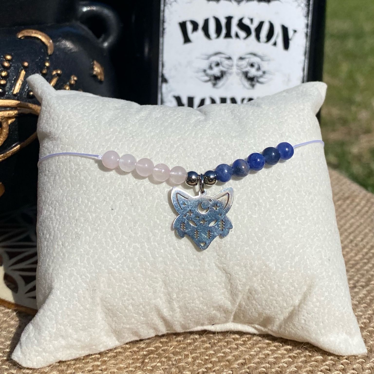 Bracelet inspiré d’Enid Sinclair, composé de quartz rose et de sodalite, avec breloque tête de loup argentée. Création artisanale douce et lumineuse, mêlant amour, confiance en soi et énergie amicale. Inspiré par la série Netflix Wednesday et le film La famille Addams.