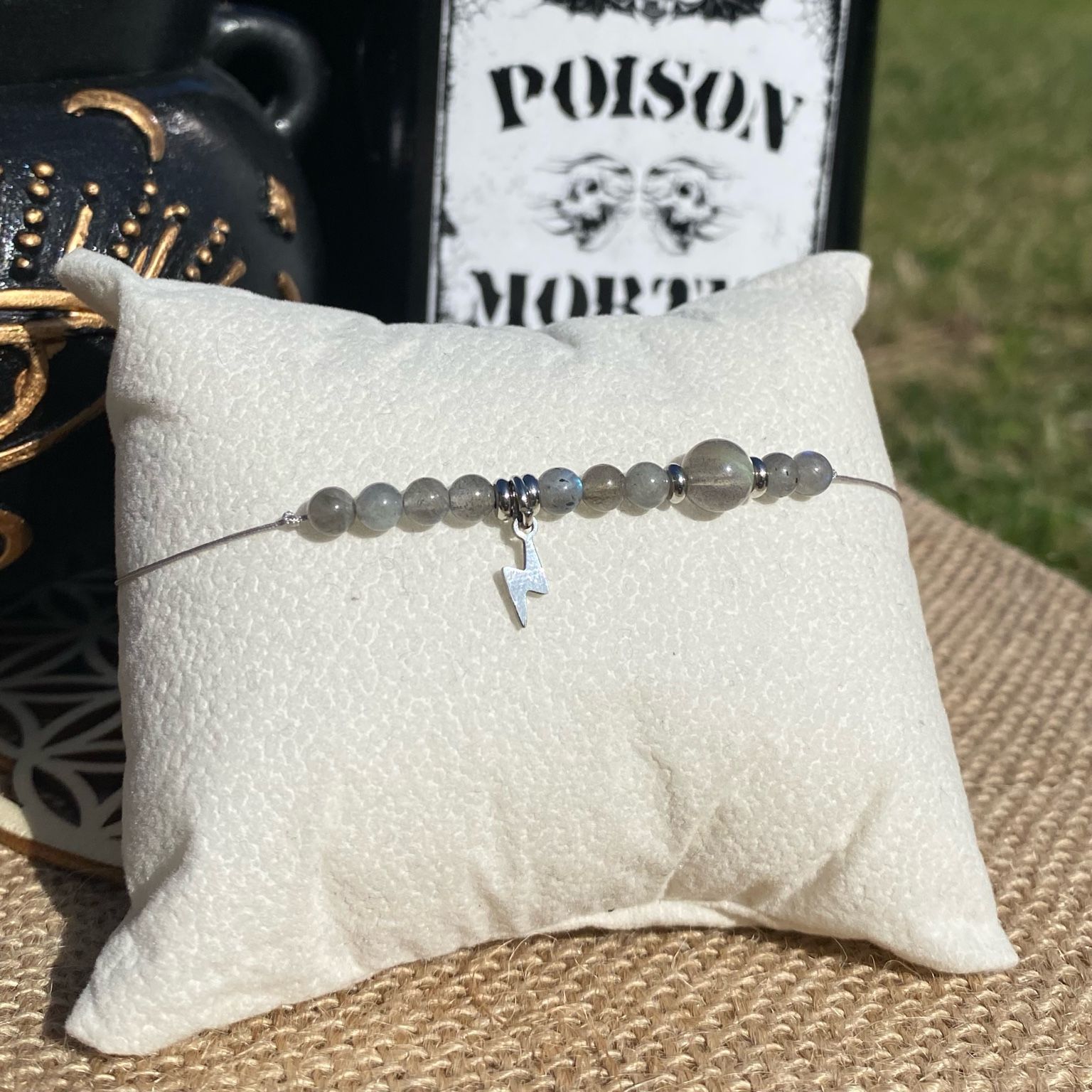 Bracelet inspirĂ© de FĂ©tide Addams, rĂ©alisĂ© Ă  la main en labradorite naturelle aux reflets mystĂ©rieux, avec breloque Ă©clair argentĂ©e. CrĂ©ation unique qui Ă©voque lâexcentricitĂ©, la curiositĂ© et la puissance Ă©nergĂ©tique du personnage. InspirĂ© par la sĂ©rie Netflix Wednesday et le film La famille Addams.