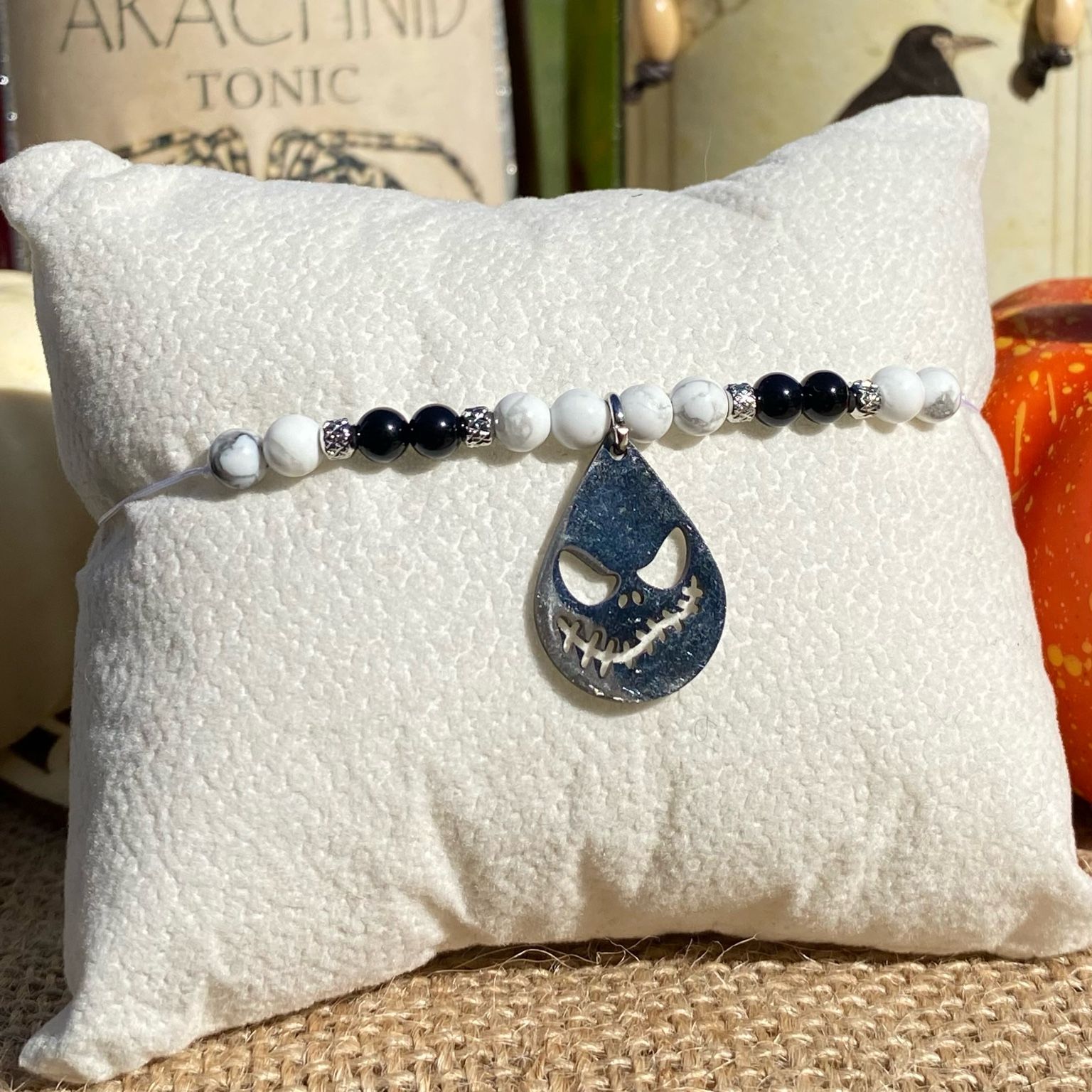 Bracelet Halloween Jack Skellington en pierres naturelles d’howlite et d’onyx noir, breloque goutte gravée en acier inoxydable, création inspirée de L’Étrange Noël de Monsieur Jack.