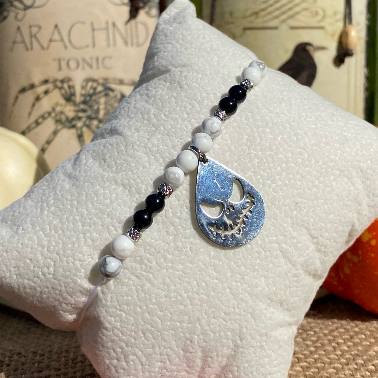 Bracelet Halloween Jack Skellington en pierres naturelles d’howlite et d’onyx noir, breloque goutte gravée en acier inoxydable, création inspirée de L’Étrange Noël de Monsieur Jack.