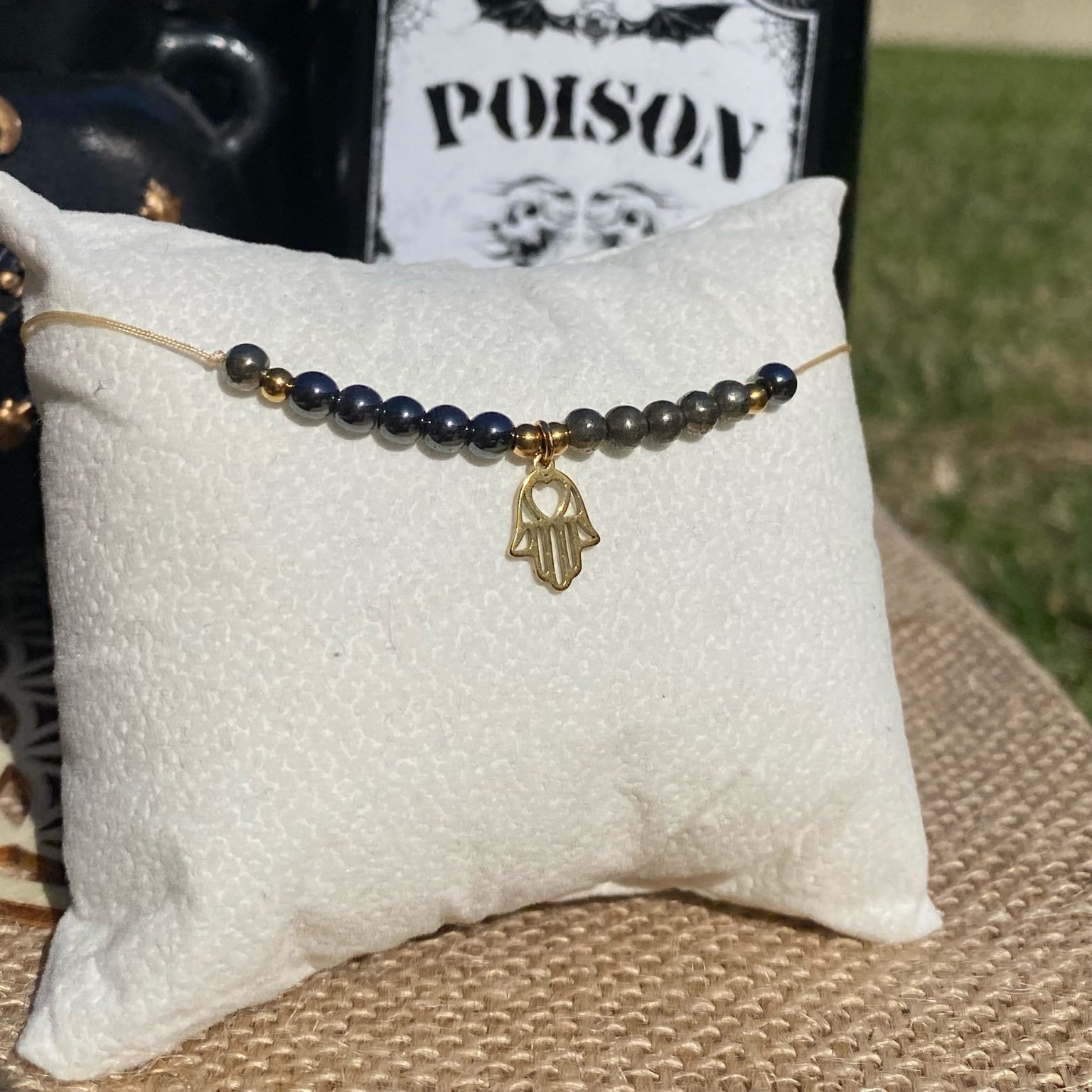 Bracelet inspiré de la Chose Addams, fait main en pyrite et hématite, orné d’une breloque main avec cœur dans la paume. Bijou mystique et macabre, symbole de la famille, de soutien et de présence amicale à toute épreuves. Inspiré par la série Netflix Wednesday et le film La famille Addams.