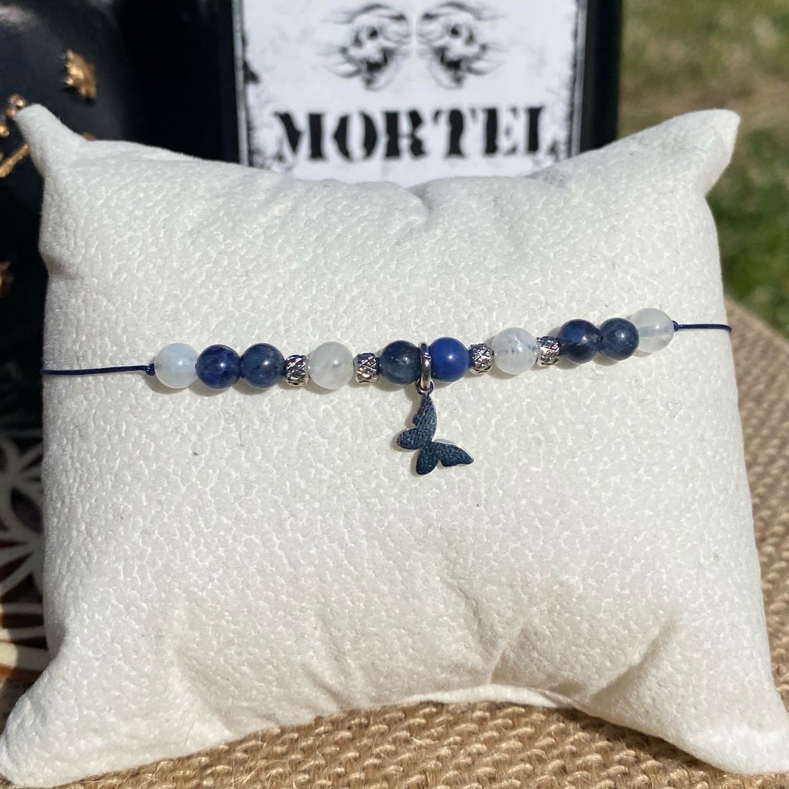 Bracelet inspiré de Xavier Thorpe, en pierres naturelles de sodalite et d’améthyste, orné d’une breloque papillon argentée. Bijou spirituel et artistique qui symbolise la créativité, l’intuition et la sensibilité. Inspiré par la série Netflix Wednesday et le film La famille Addams.
