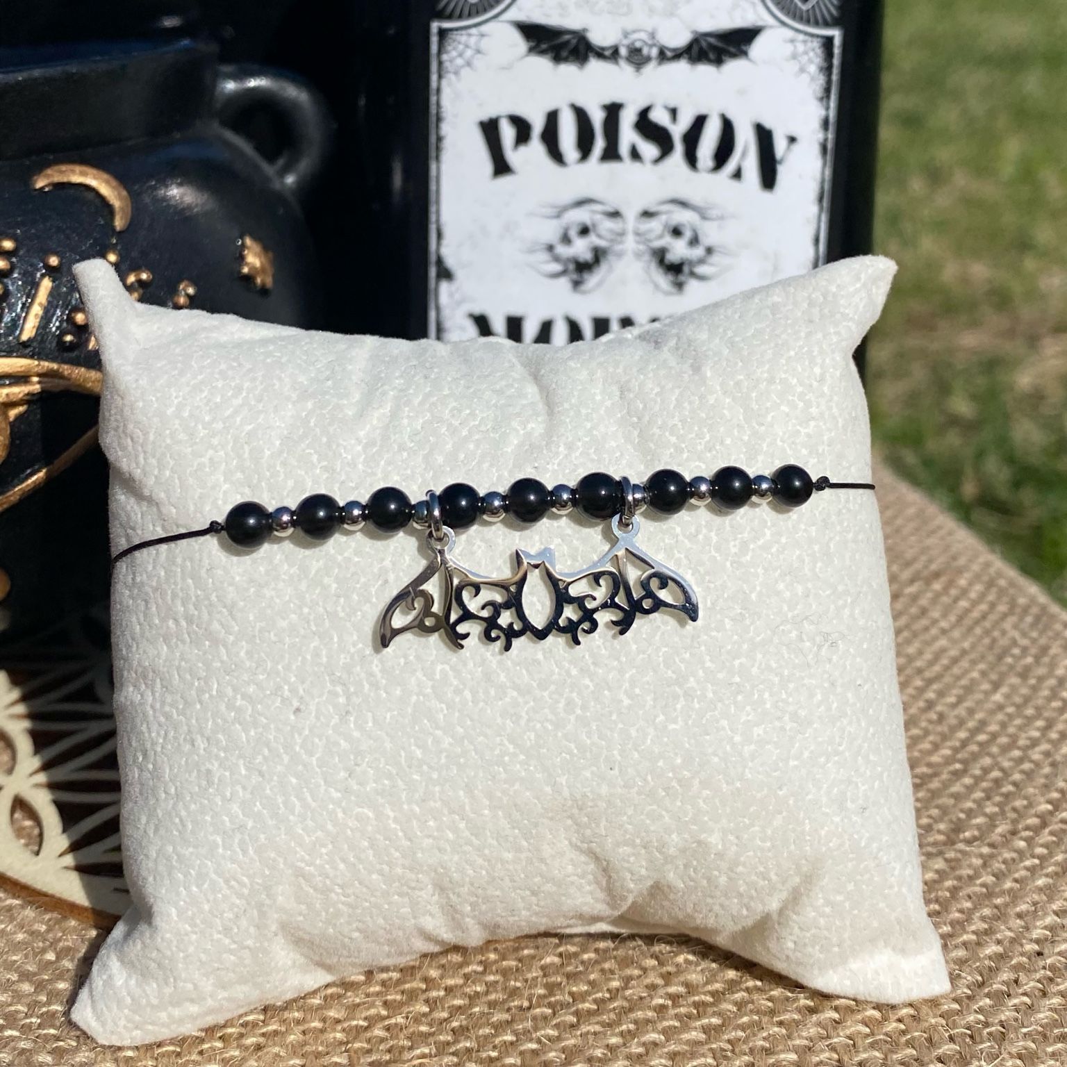 Bracelet inspiré de Mercredi Addams, fait main en obsidienne noire, avec breloque chauve-souris argentée en acier inoxydable. Bijou sombre et raffiné, symbole de protection, d’ancrage et d’indépendance. Inspiré par la série Netflix Wednesday et le film La famille Addams