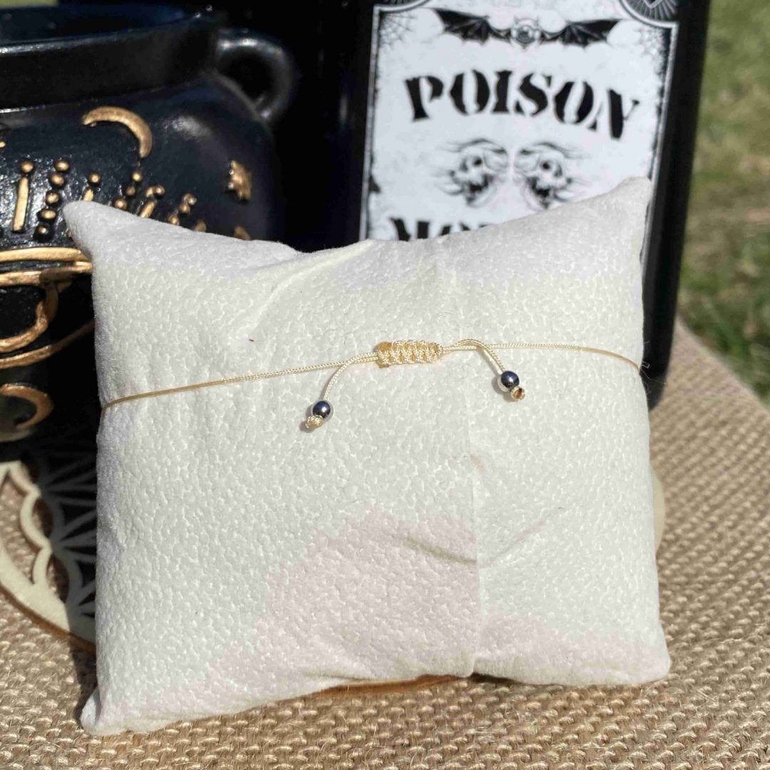 Bracelet inspiré de Puglsey Addams, en jaspe dalmatien, apprêts dorés en acier inoxydable et une breloque couteau doré. Inspiré par la série Netflix Wednesday et le film La famille Addams.