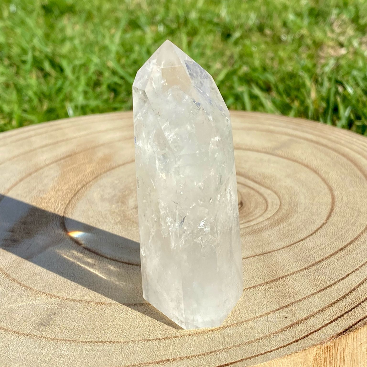 Pointe de cristal de roche naturelle avec inclusions laiteuses, pierre translucide aux reflets brumeux pour apaisement et pureté.
