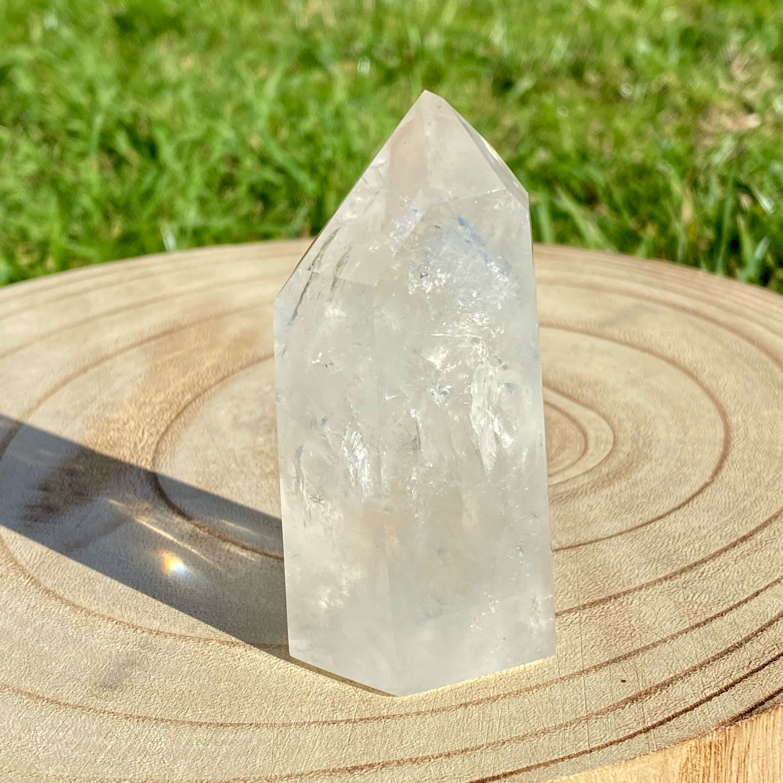 Pointe de cristal de roche naturelle avec inclusions laiteuses, pierre translucide aux reflets brumeux pour apaisement et pureté.