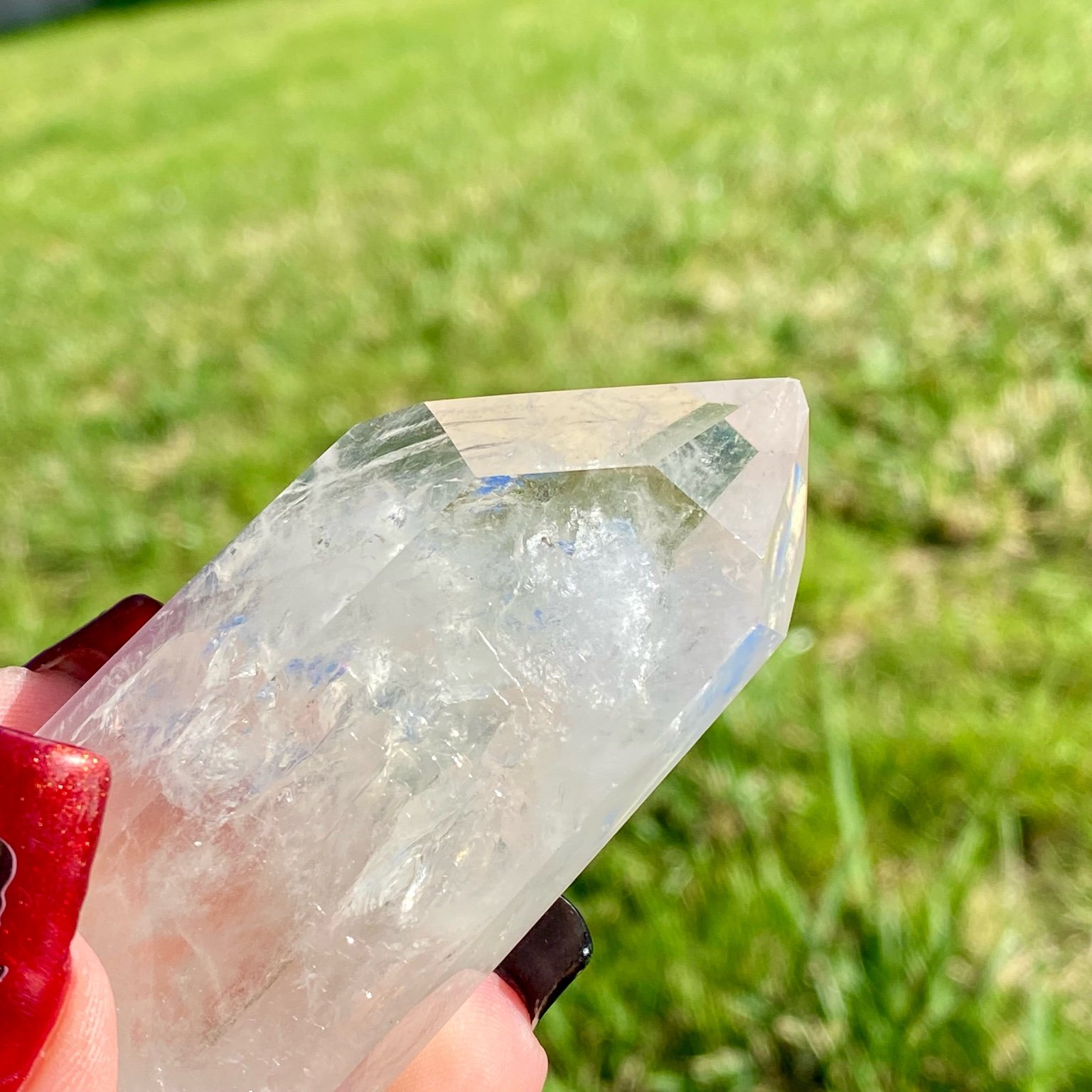 Pointe de cristal de roche naturelle avec inclusions laiteuses, pierre translucide aux reflets brumeux pour apaisement et pureté.