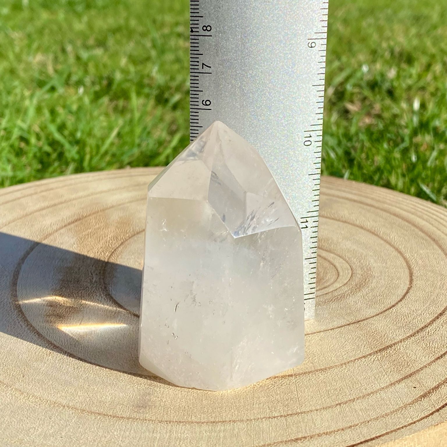 Pointe de cristal de roche naturelle avec inclusions laiteuses, pierre translucide aux reflets brumeux pour apaisement et pureté.