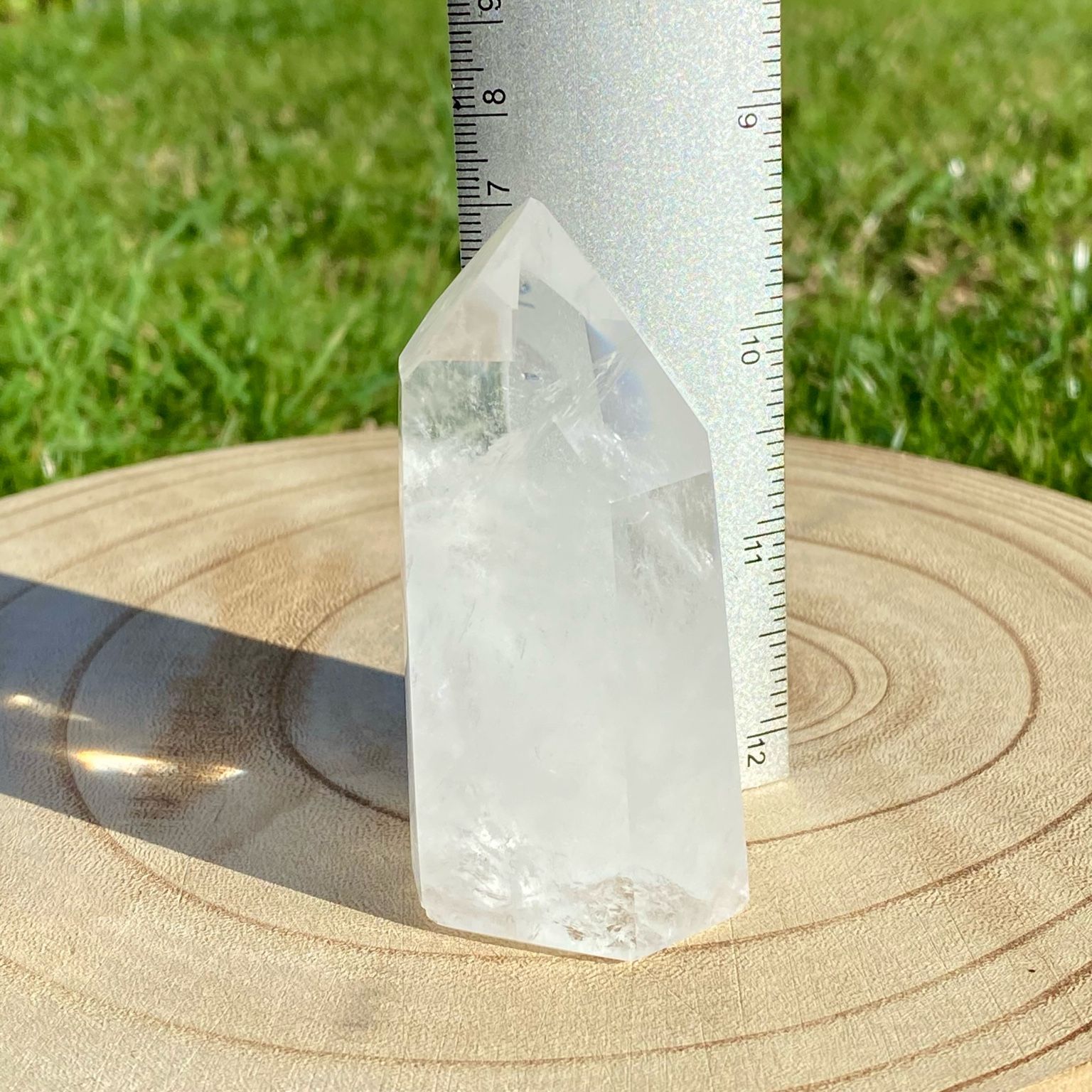 Pointe de cristal de roche naturelle avec inclusions laiteuses, pierre translucide aux reflets brumeux pour apaisement et pureté.