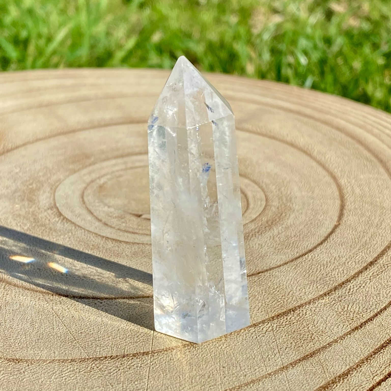 Pointe de cristal de roche translucide naturelle, pierre claire et lumineuse symbolisant la pureté et la clarté énergétique.