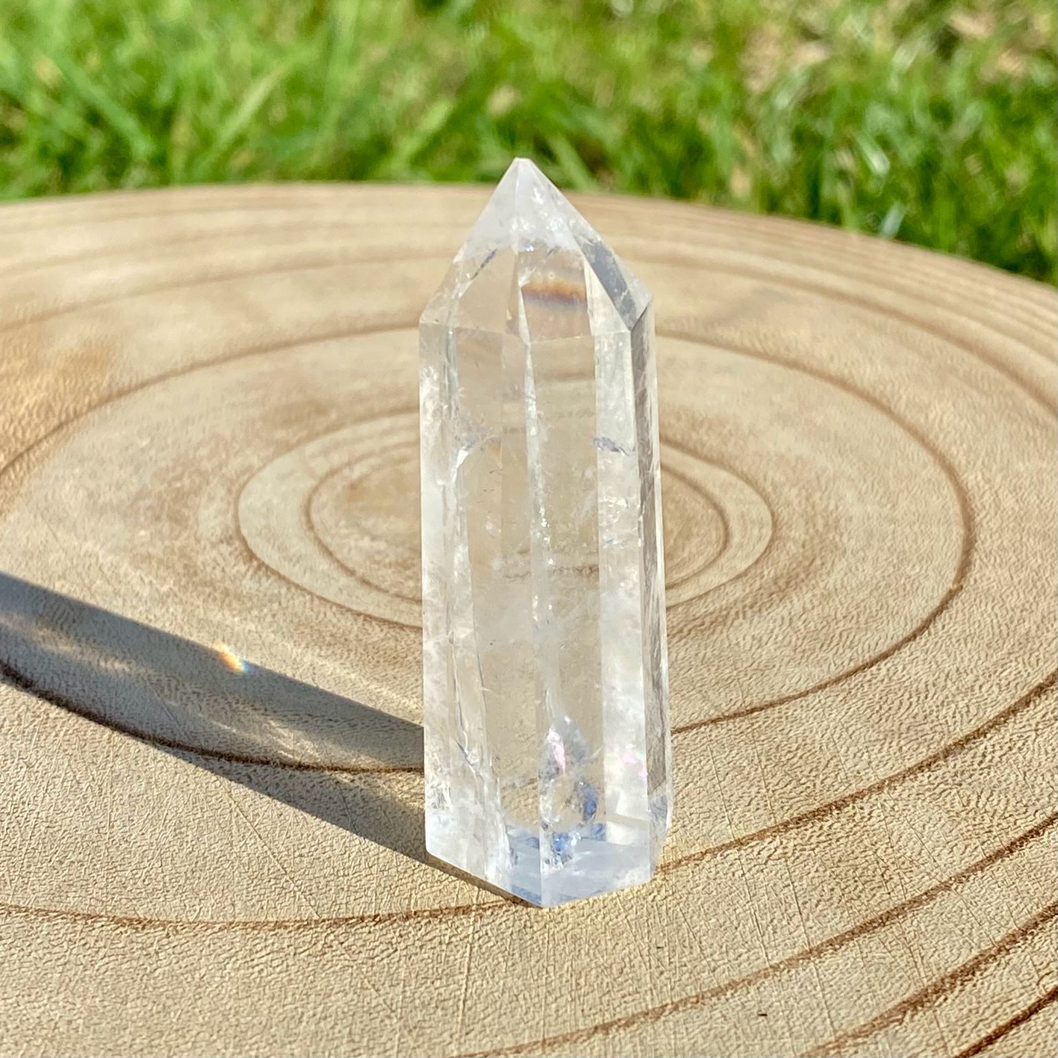 Pointe de cristal de roche translucide naturelle, pierre claire et lumineuse symbolisant la pureté et la clarté énergétique.