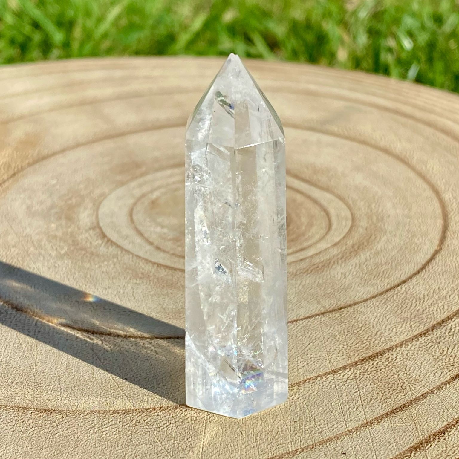 Pointe de cristal de roche translucide naturelle, pierre claire et lumineuse symbolisant la pureté et la clarté énergétique.