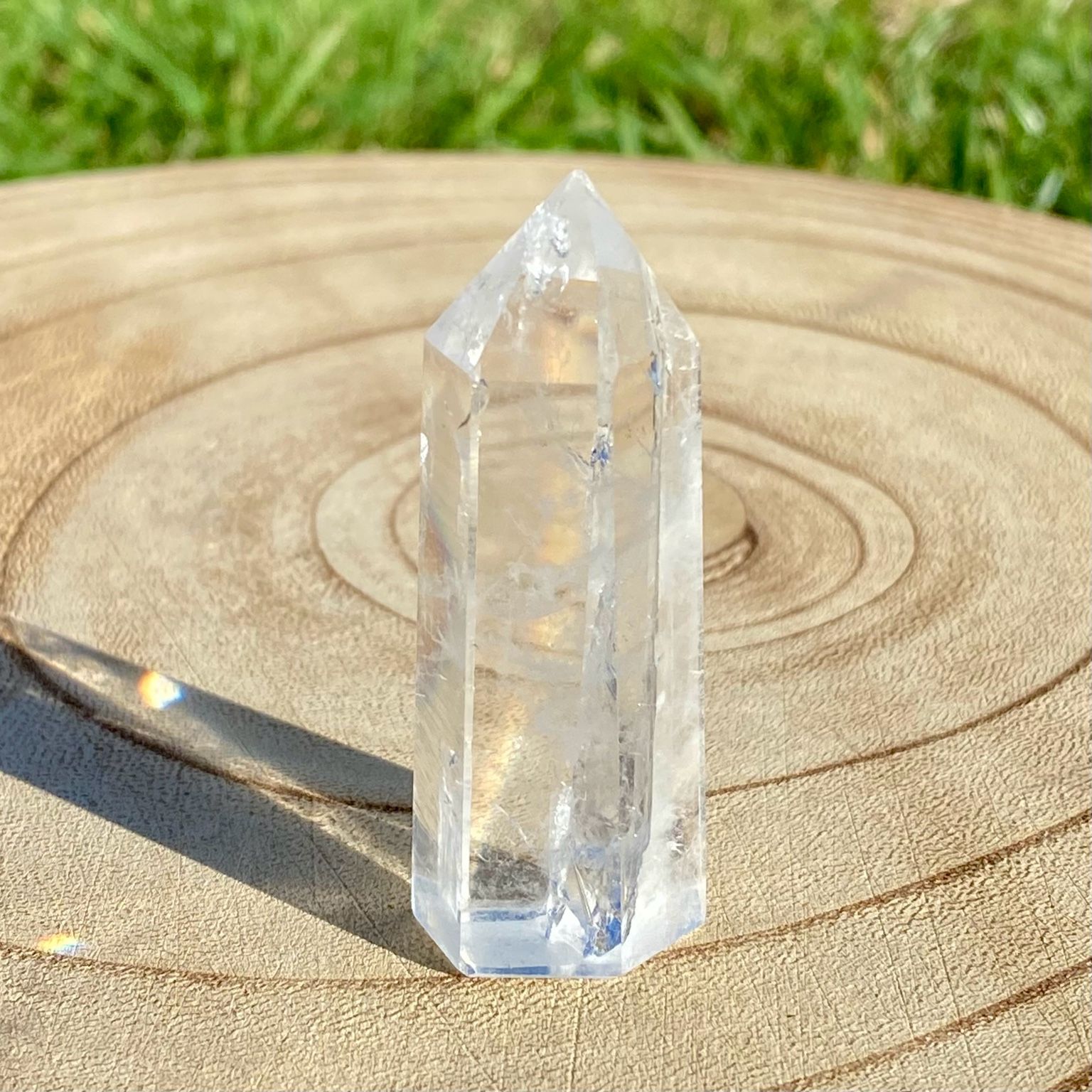 Pointe de cristal de roche translucide naturelle, pierre claire et lumineuse symbolisant la pureté et la clarté énergétique.