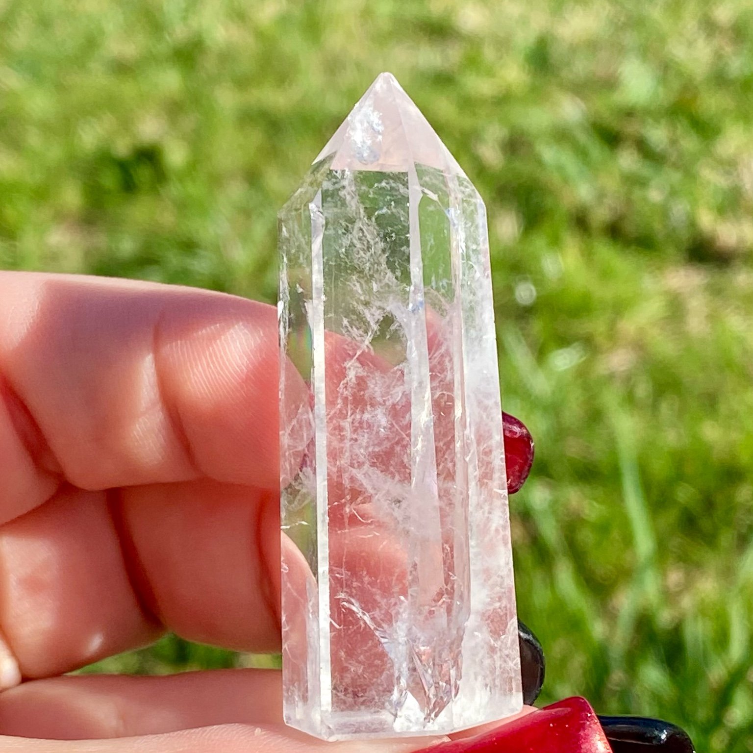 Pointe de cristal de roche translucide naturelle, pierre claire et lumineuse symbolisant la pureté et la clarté énergétique.