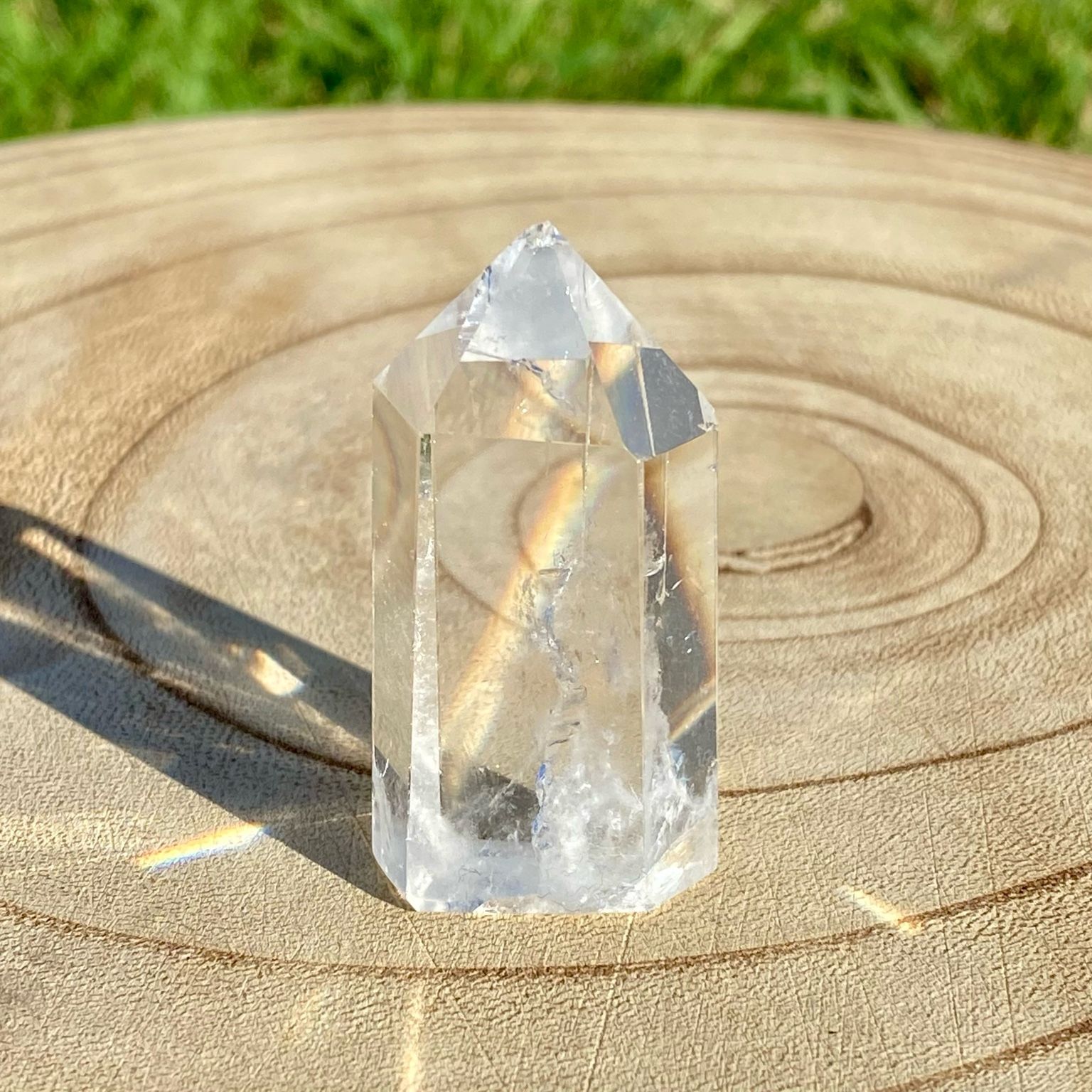 Pointe de cristal de roche translucide naturelle, pierre claire et lumineuse symbolisant la pureté et la clarté énergétique.