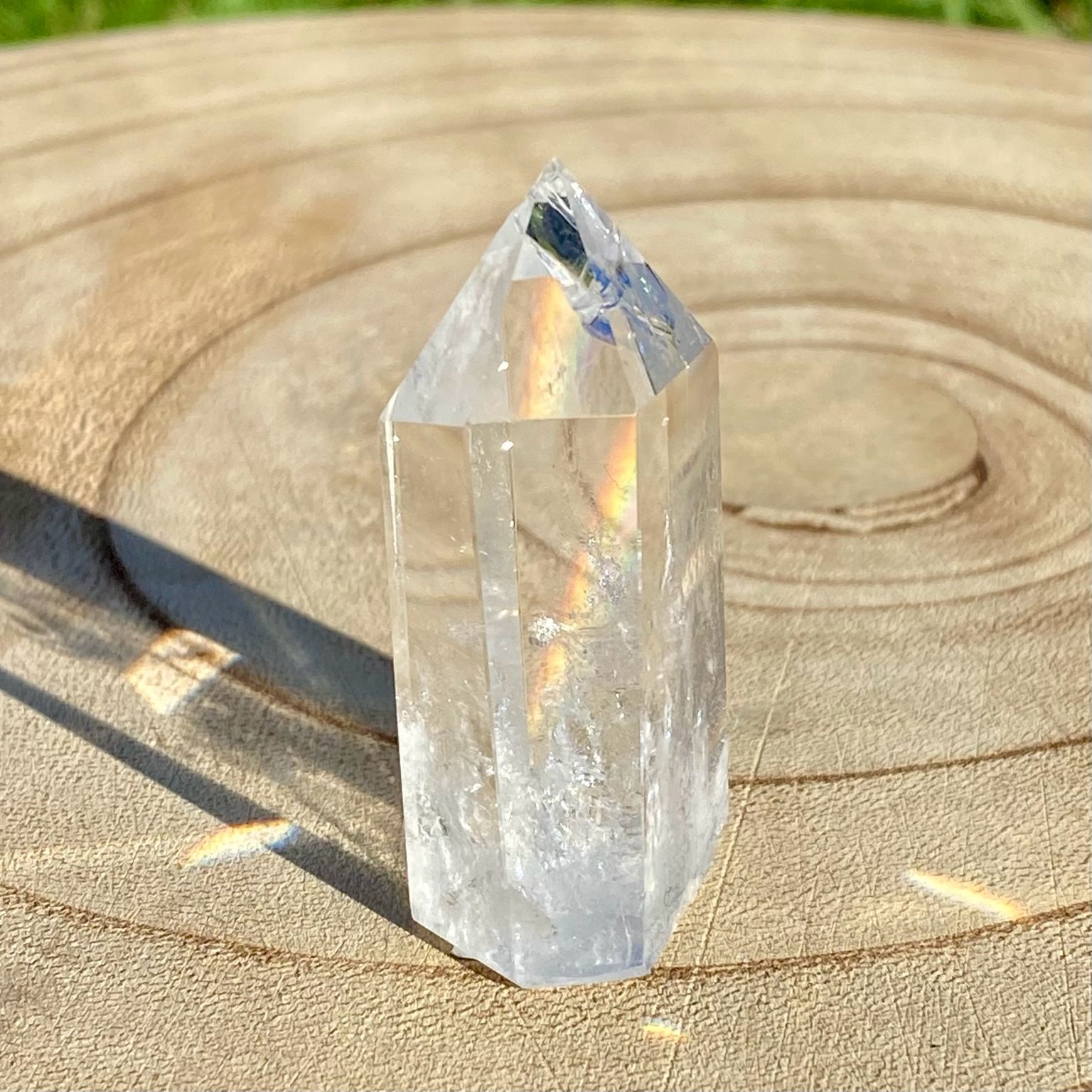 Pointe de cristal de roche translucide naturelle, pierre claire et lumineuse symbolisant la pureté et la clarté énergétique.