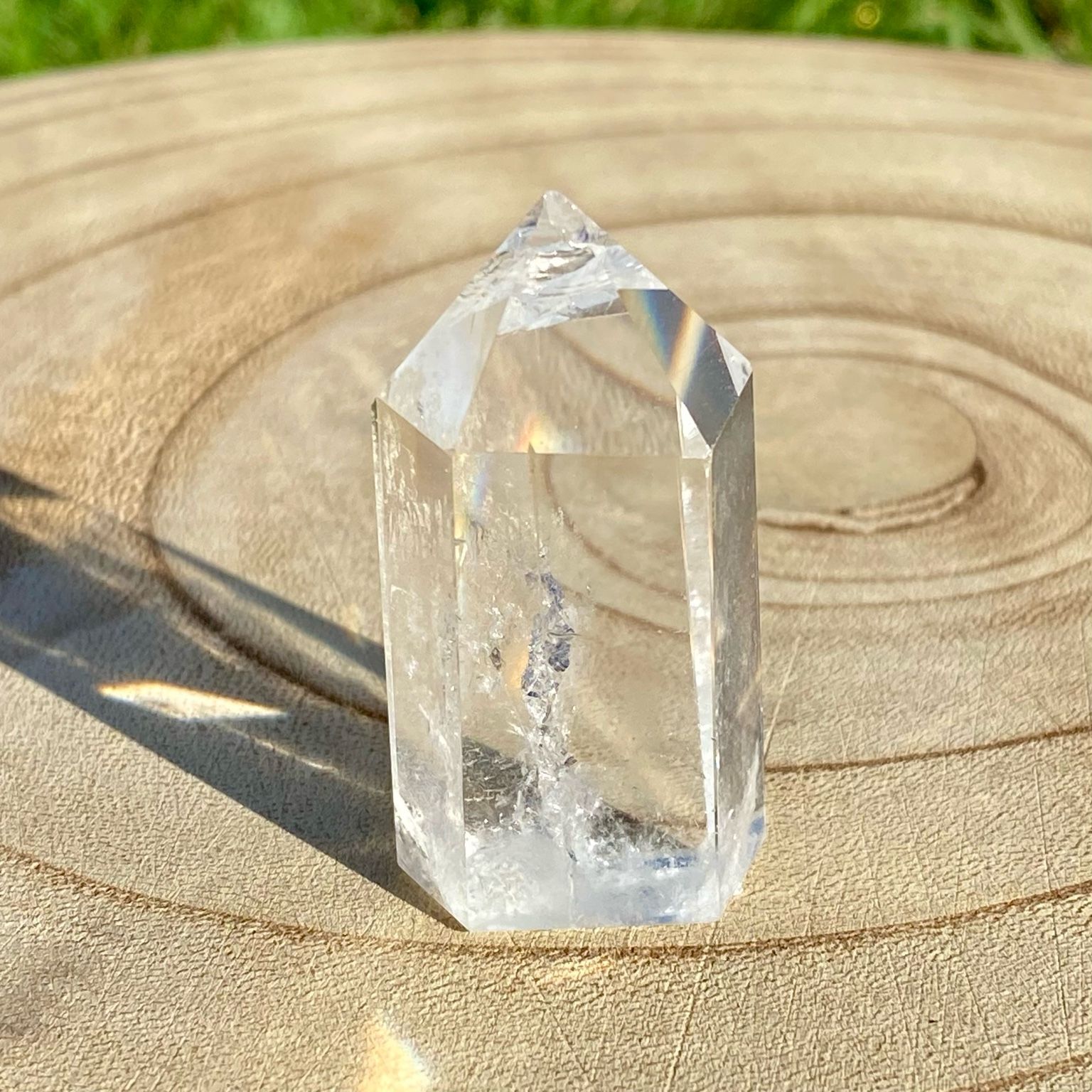 Pointe de cristal de roche translucide naturelle, pierre claire et lumineuse symbolisant la pureté et la clarté énergétique.
