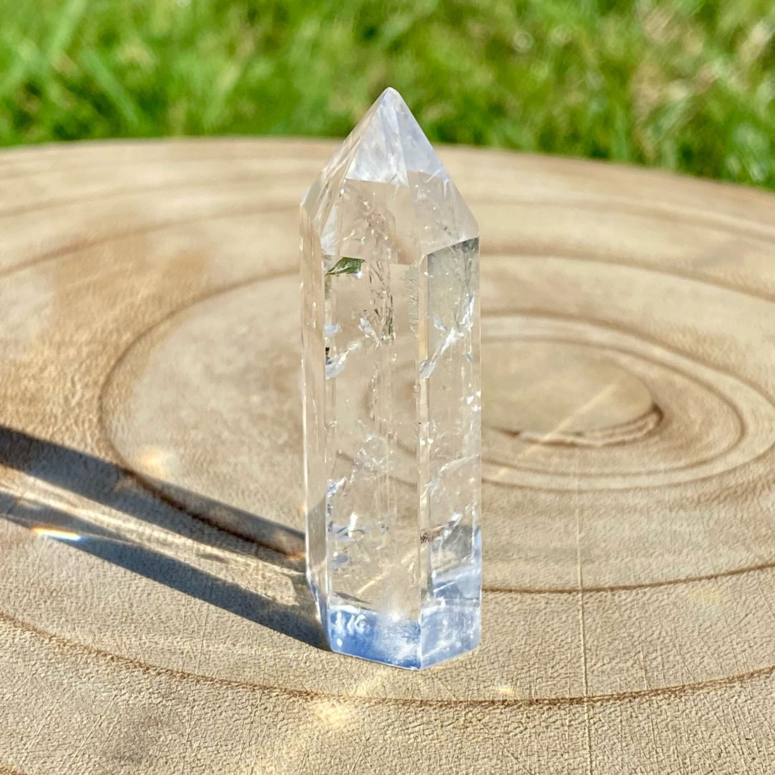 Pointe de cristal de roche translucide naturelle, pierre claire et lumineuse symbolisant la pureté et la clarté énergétique. Les merveilles by Pauline, lithothérapie.