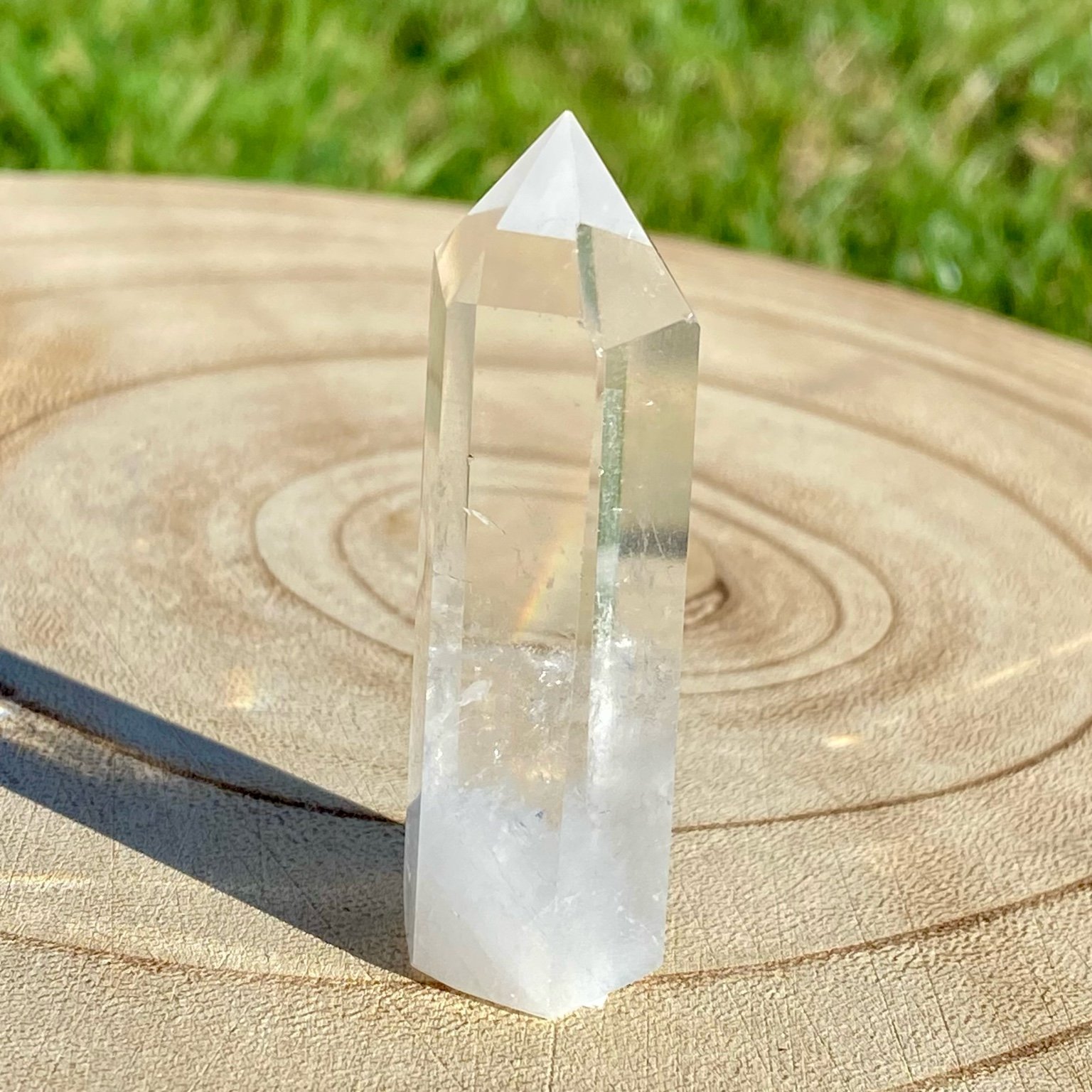 Pointe de cristal de roche translucide naturelle, pierre claire et lumineuse symbolisant la pureté et la clarté énergétique. Les merveilles by Pauline, lithothérapie.