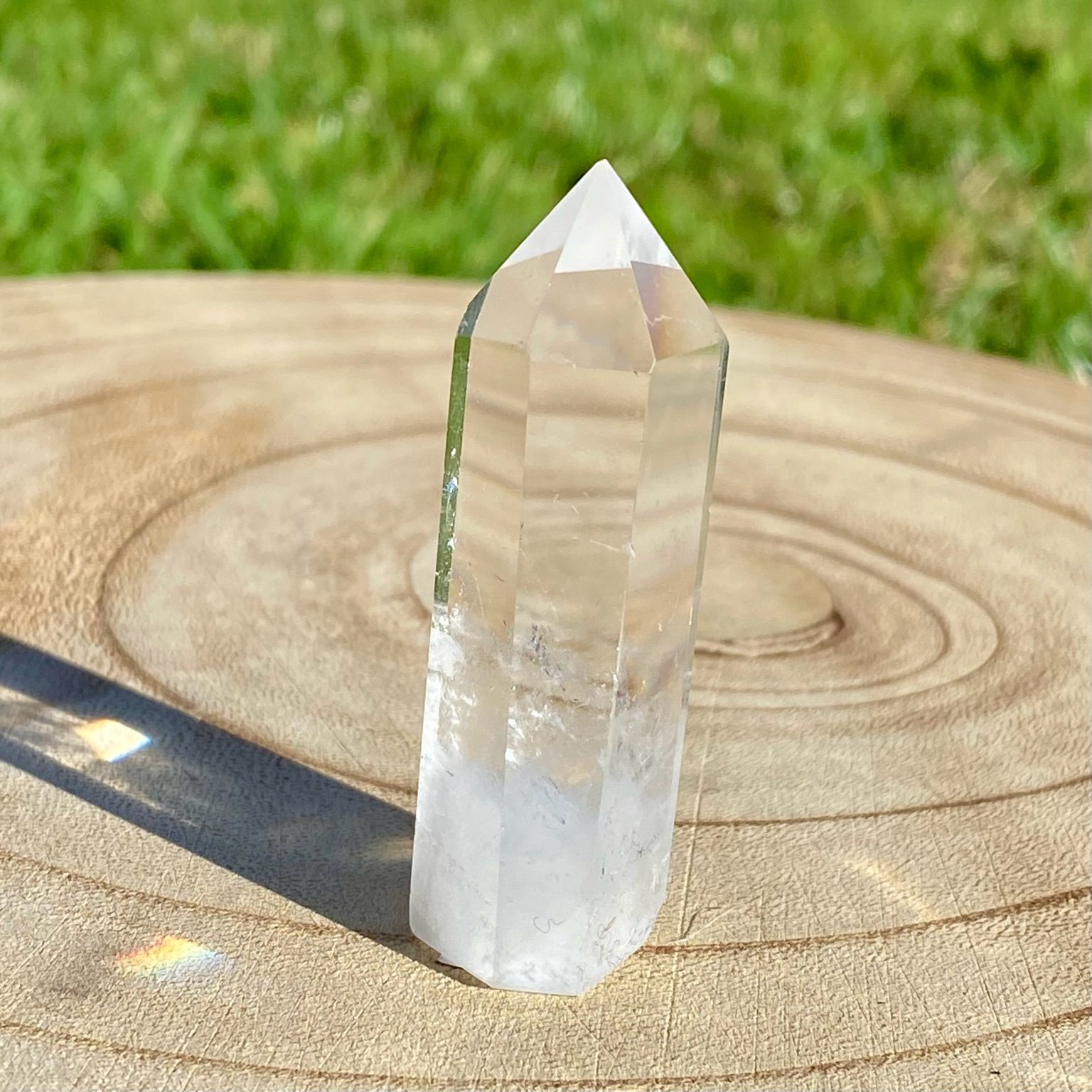 Pointe de cristal de roche translucide naturelle, pierre claire et lumineuse symbolisant la pureté et la clarté énergétique. Les merveilles by Pauline, lithothérapie.