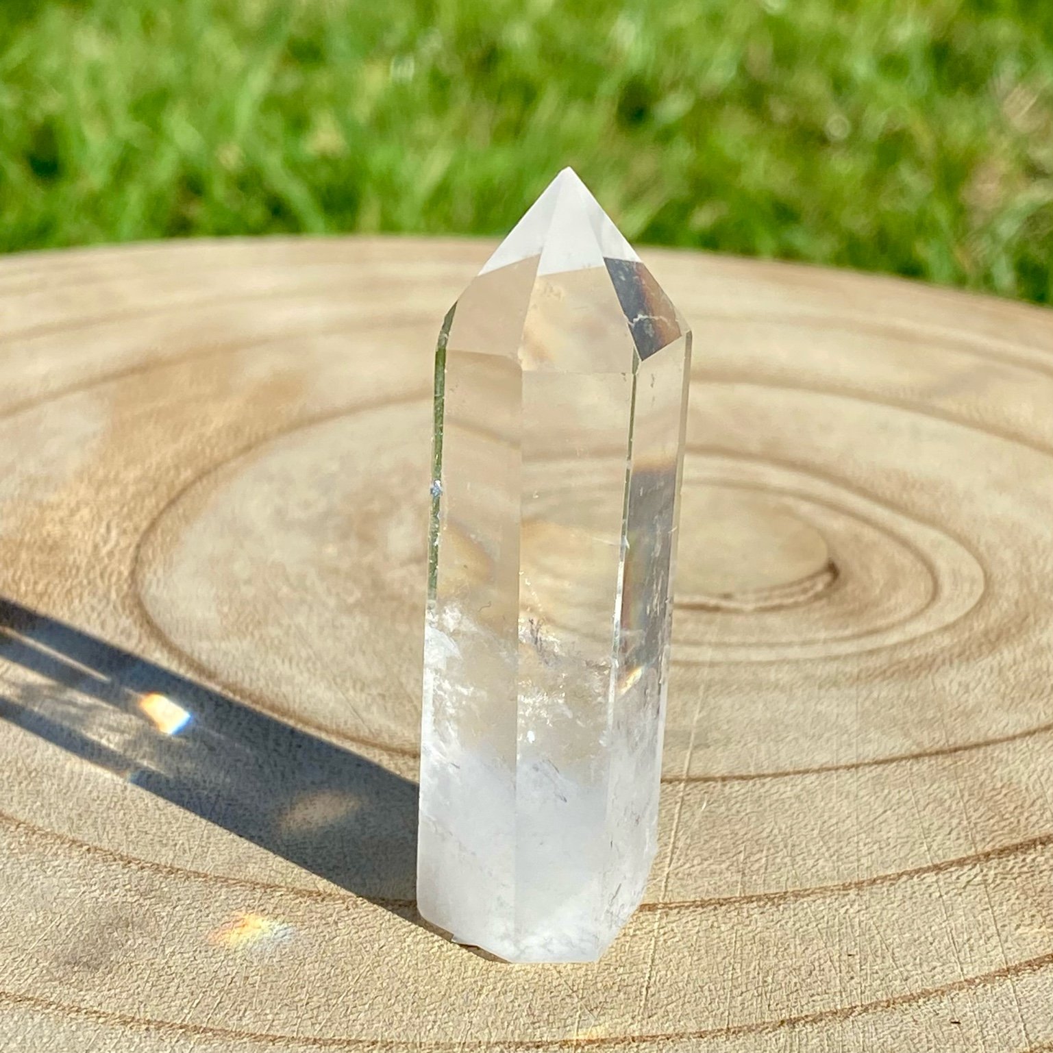 Pointe de cristal de roche translucide naturelle, pierre claire et lumineuse symbolisant la pureté et la clarté énergétique. Les merveilles by Pauline, lithothérapie.